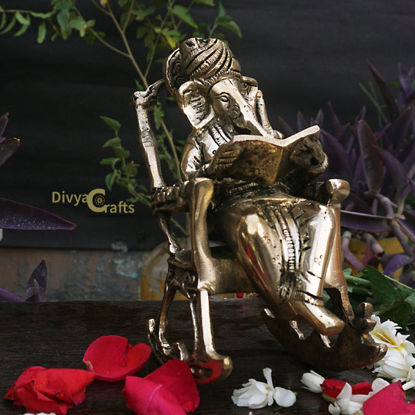 Barss Ganesha seated on a Rocking Chair reading Ramayan